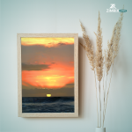 A group of individuals gathered on the beach, silhouetted against a vibrant sunset sky.