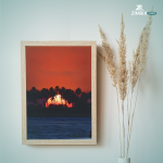 A man stands on the beach, gazing at the sun as it sets on the horizon, creating a serene and contemplative atmosphere.